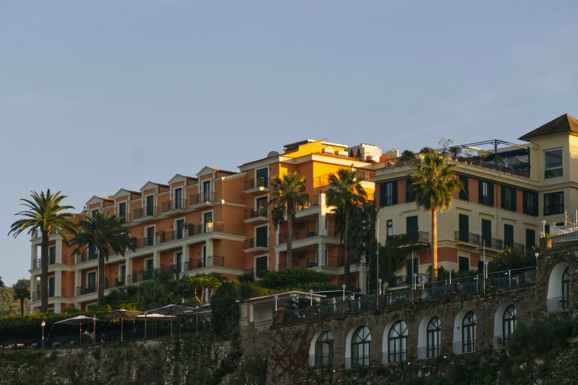 Mediterranean hotel architecture illuminated by warm evening light, illustrating the Maison Sorelle studio concept